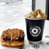 Sort dobbeltlagspapkrus med 'Black box donuts' logotryk brugt til at servere en kop varm kakao